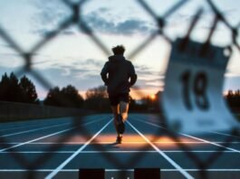 Powerful Motivational Sports Quotes to Inspire You During Tough Times Lone runner at dawn on rainy track.